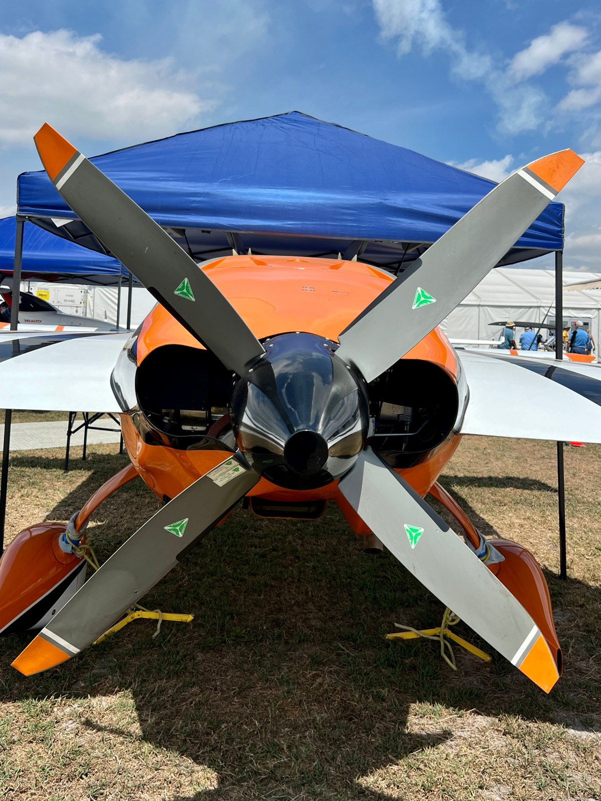 Orange aerobatic aircraft with a four-blade gray MT propeller under a blue canopy