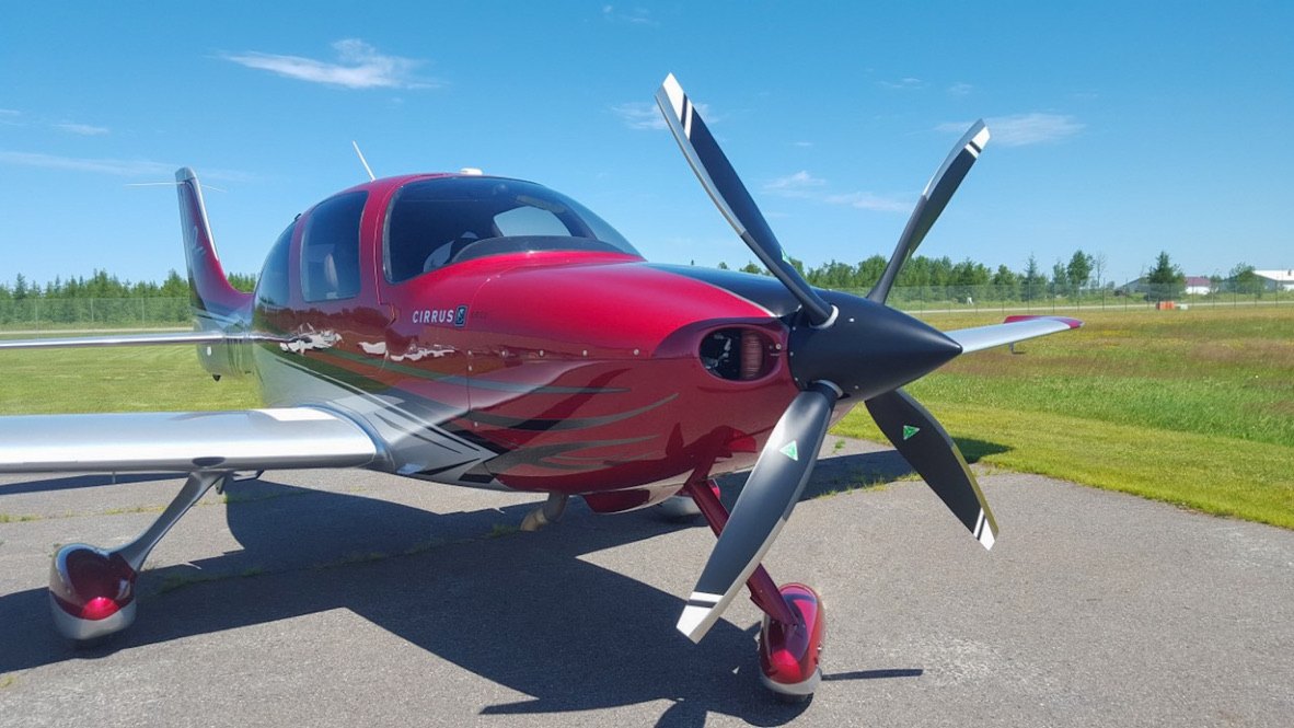Red Cirrus with a black five-blade MT propeller on the ramp