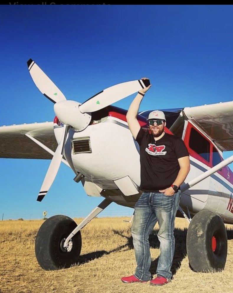 Man in a cap standing in front of a white Cessna with a white three-blade MT propeller