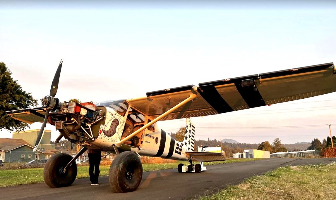 Large-tire STOL bush plane number 22 on a paved road with a black MT propeller