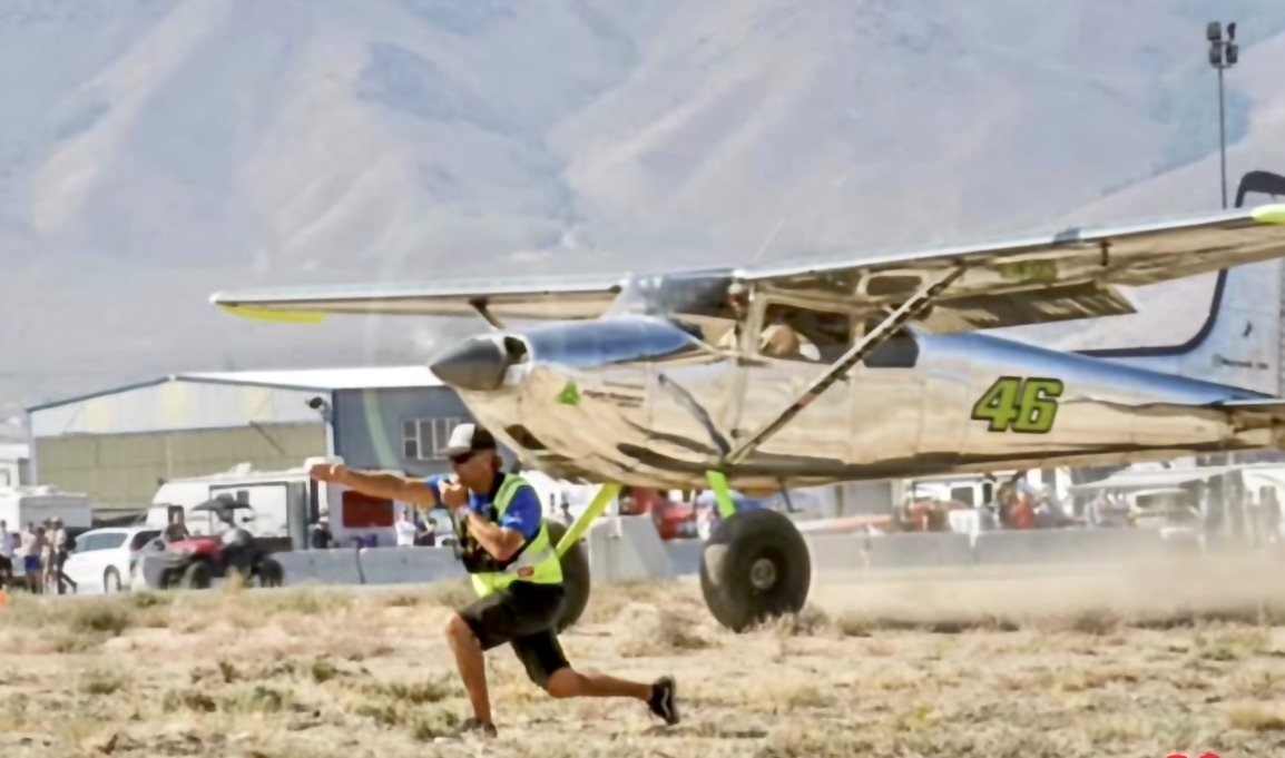 Polished chrome Cessna with the number 46 and a man crouching in front of it